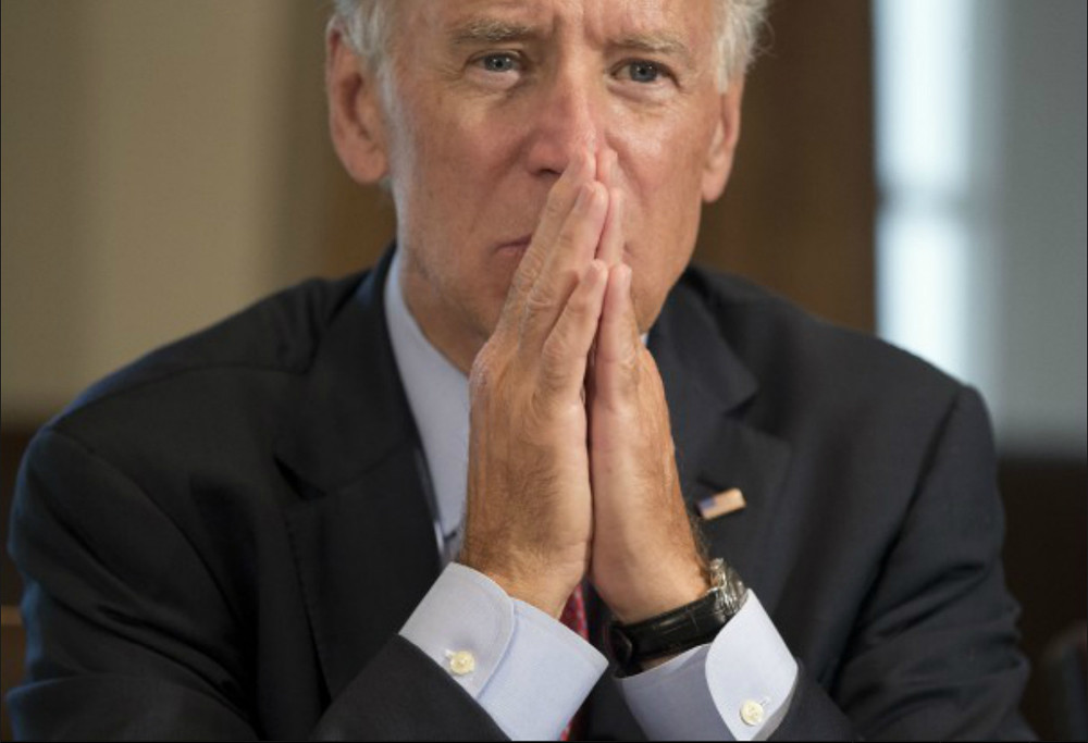 President Joe Biden hands clasped as if thinking